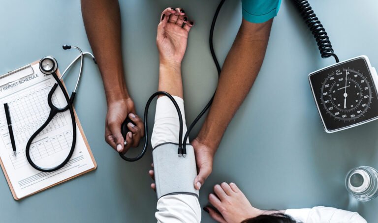 Clinician checking a patient’s blood pressure during assessment